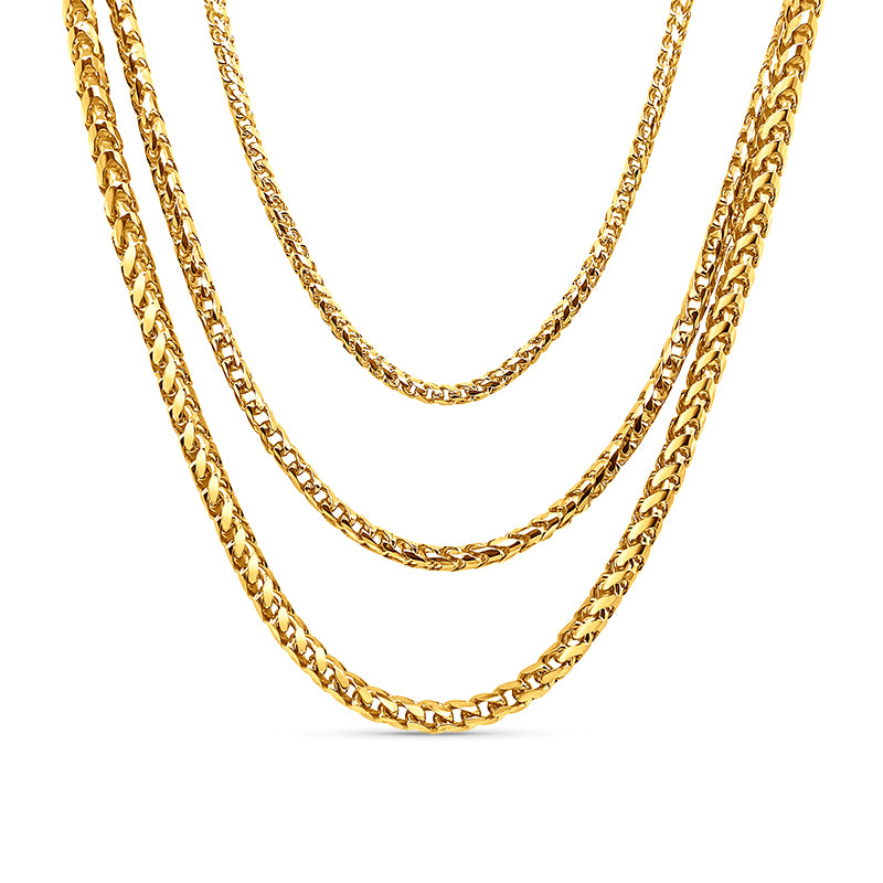 Three gold Cuban link chains on a white background