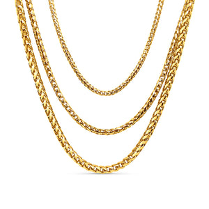 Three gold Cuban link chains on a white background