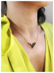 Model in a yellow shirt wearing the Feather Pendant on her neck