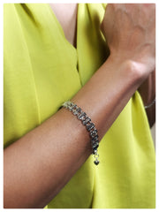 Model wearing the Ava Bracelet on her wrist with a green shirt