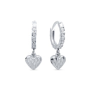 Pair of heart-shaped silver hoop earrings on a white background.