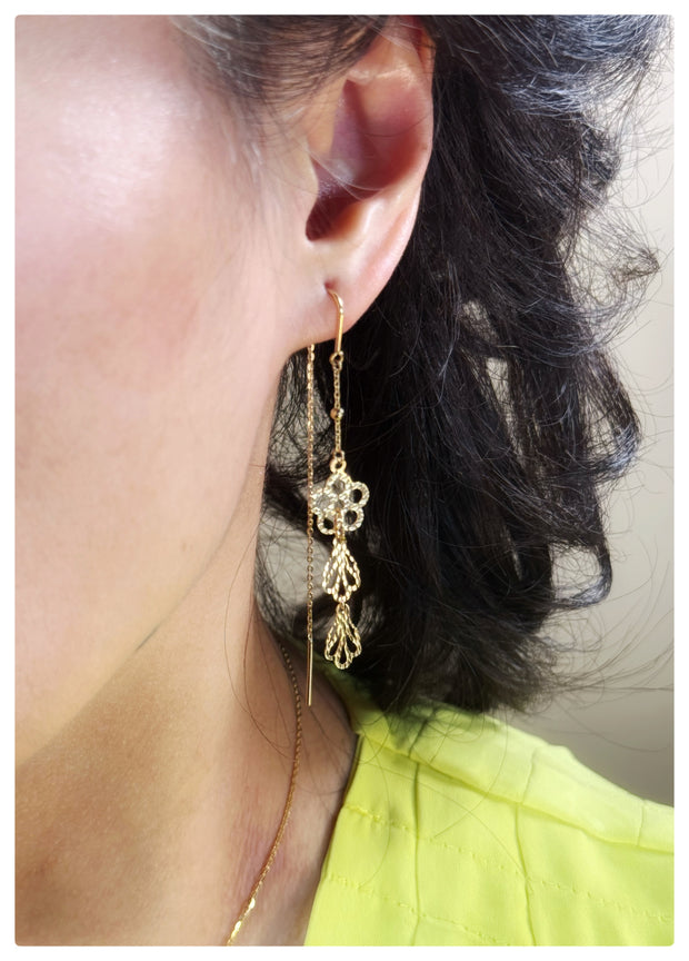 Model wearing the Kiran earrings and is wearing a yellow shirt. 