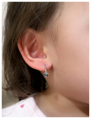 18K white gold earrings on a baby's ear