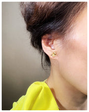 Model is wearing the pansy studs in yellow gold on her ear