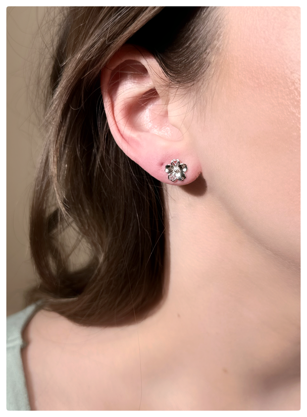 Model is wearing a pansy studs in 18K white gold on her ear