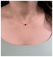 Model is wearing the Rosa Pendant which is Garnet and diamond around her neck